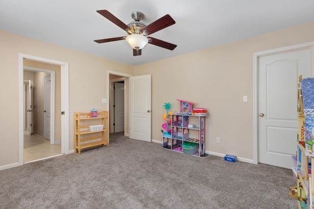 recreation room featuring carpet, a ceiling fan, and baseboards