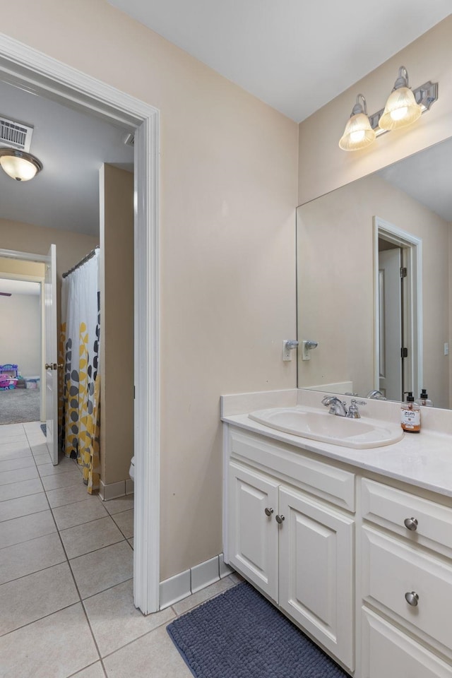 bathroom with tile patterned floors, vanity, toilet, and baseboards