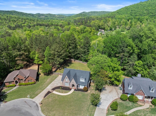 aerial view of property and surrounding area featuring a forest