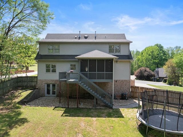 rear view of house featuring a trampoline, a sunroom, french doors, stairway, and central AC