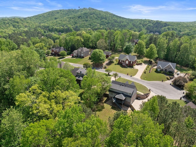 aerial view of residential area featuring a heavily wooded area and mountains