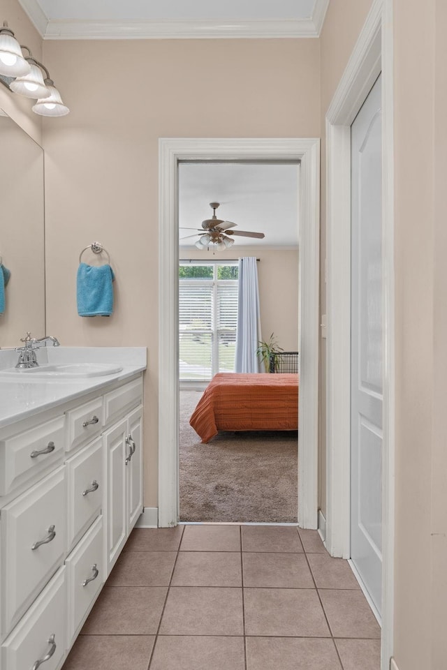 bathroom with crown molding, tile patterned flooring, vanity, ceiling fan, and baseboards