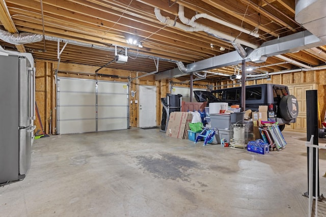 garage featuring freestanding refrigerator and a garage door opener