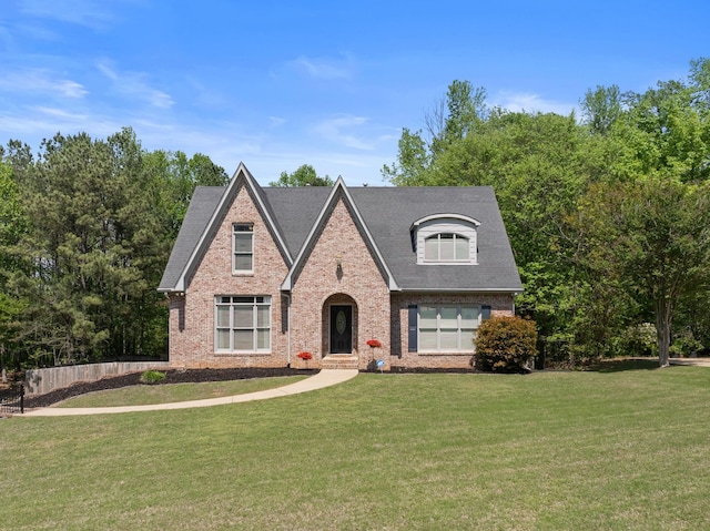 view of front of house featuring brick siding and a front yard