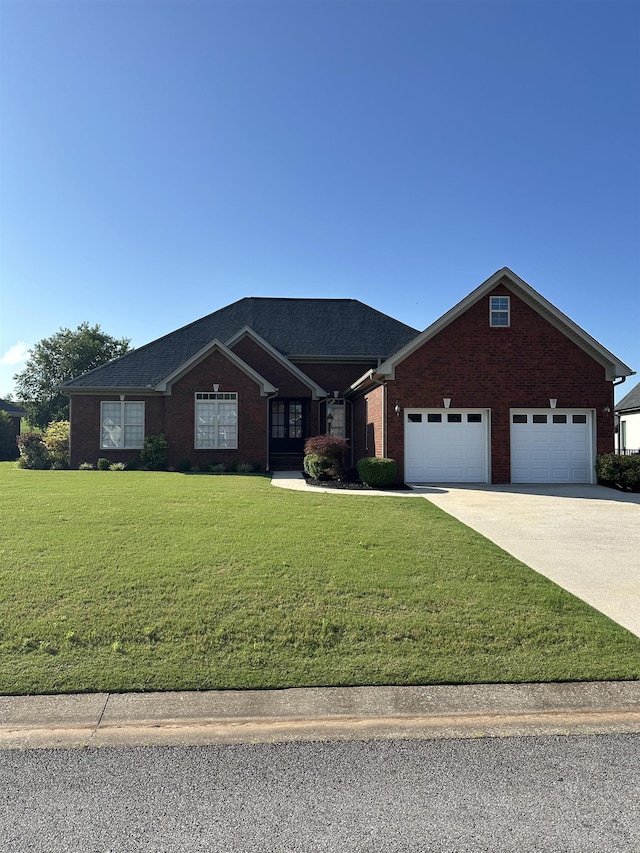 - view of front of home with an attached garage, a front yard, driveway, brick siding, and french doors