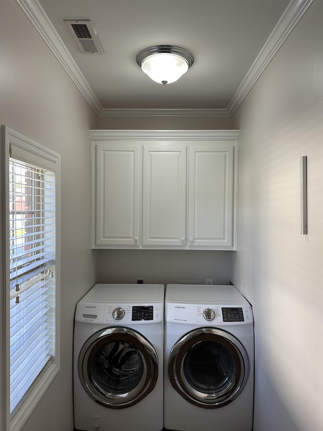  - washroom featuring washer and clothes dryer, cabinet space, and ornamental molding
