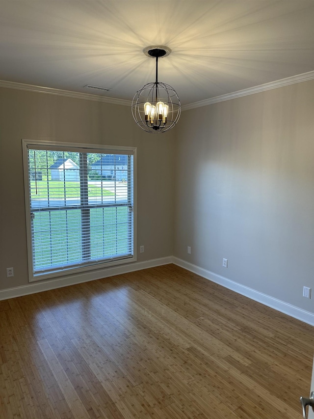  - spare room with a chandelier, ornamental molding, and wood finished floors