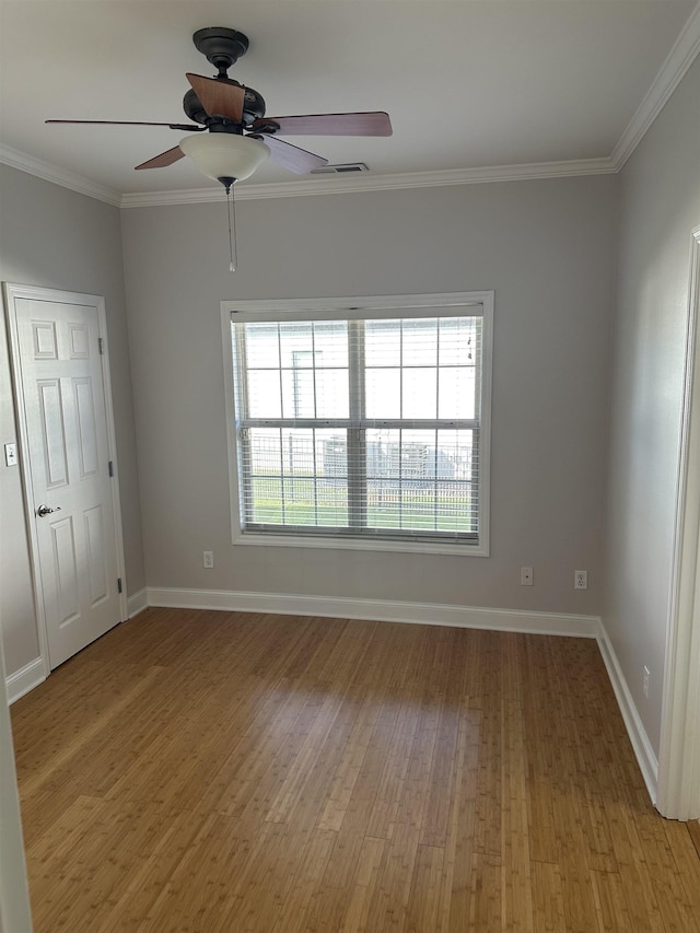  - empty room with crown molding, light wood-style flooring, and a ceiling fan