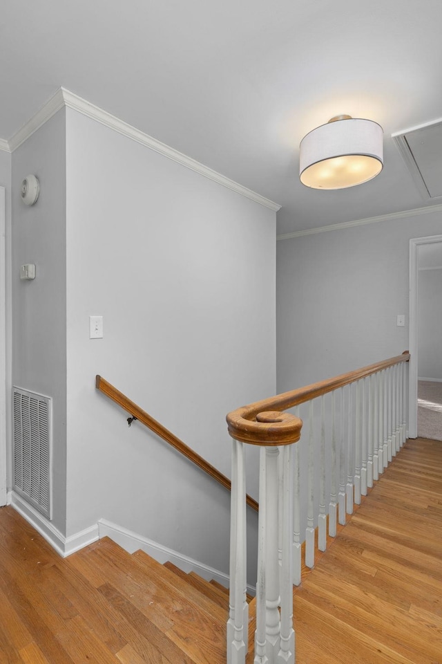 stairway featuring crown molding and wood-type flooring