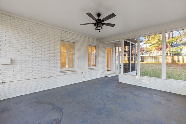 unfurnished sunroom with ceiling fan