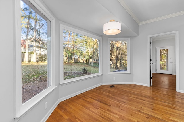 unfurnished dining area with crown molding and hardwood / wood-style floors