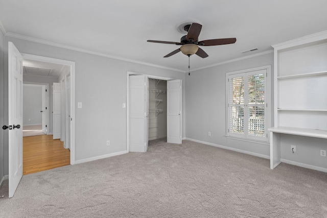 unfurnished bedroom with crown molding, light colored carpet, ceiling fan, and a closet