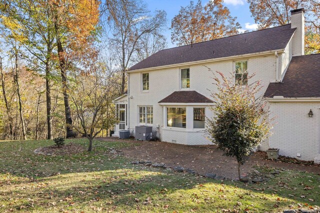 back of property with central AC, a yard, and a patio area