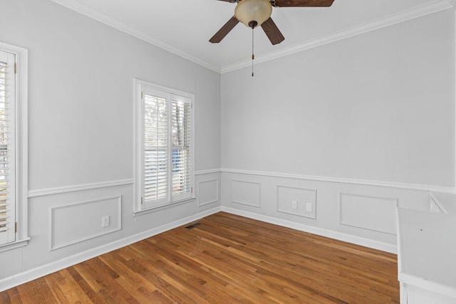 empty room with wood-type flooring, a healthy amount of sunlight, ceiling fan, and ornamental molding