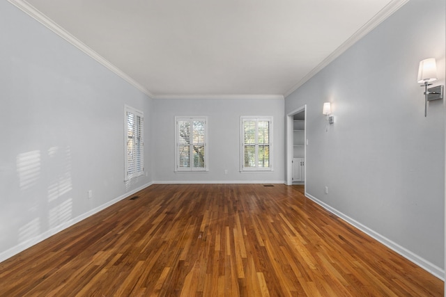 spare room featuring dark hardwood / wood-style flooring and crown molding