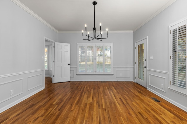 unfurnished dining area featuring crown molding, a chandelier, and dark wood-type flooring