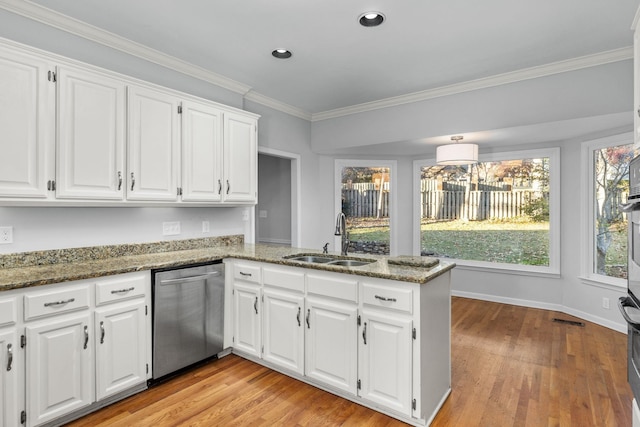 kitchen featuring sink, kitchen peninsula, white cabinets, stainless steel dishwasher, and dark stone counters