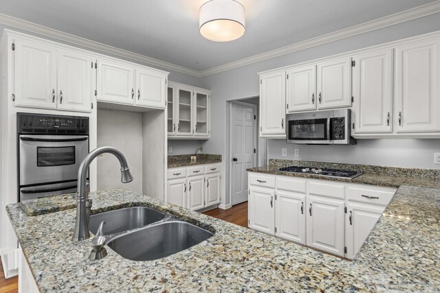 kitchen with stone counters, white cabinetry, appliances with stainless steel finishes, and crown molding