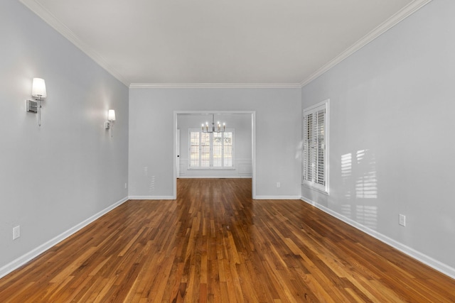 spare room with ornamental molding, dark hardwood / wood-style floors, and a notable chandelier