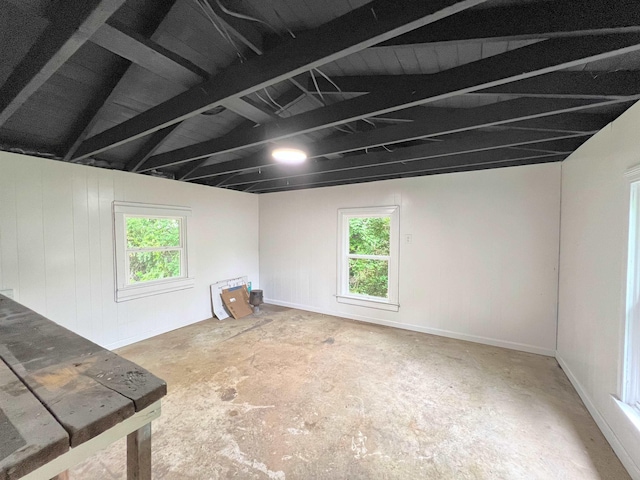  - empty room with plenty of natural light, concrete floors, and beam ceiling