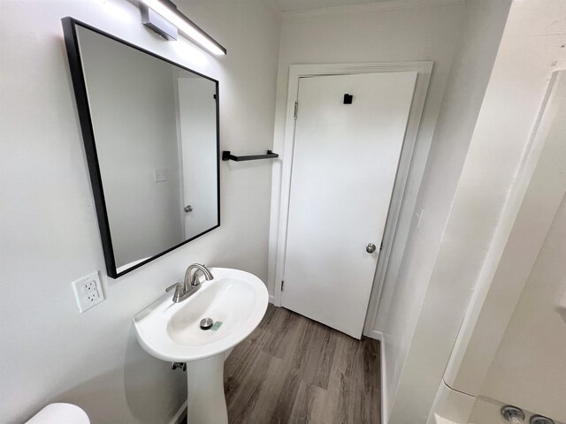 - bathroom featuring wood finished floors and toilet