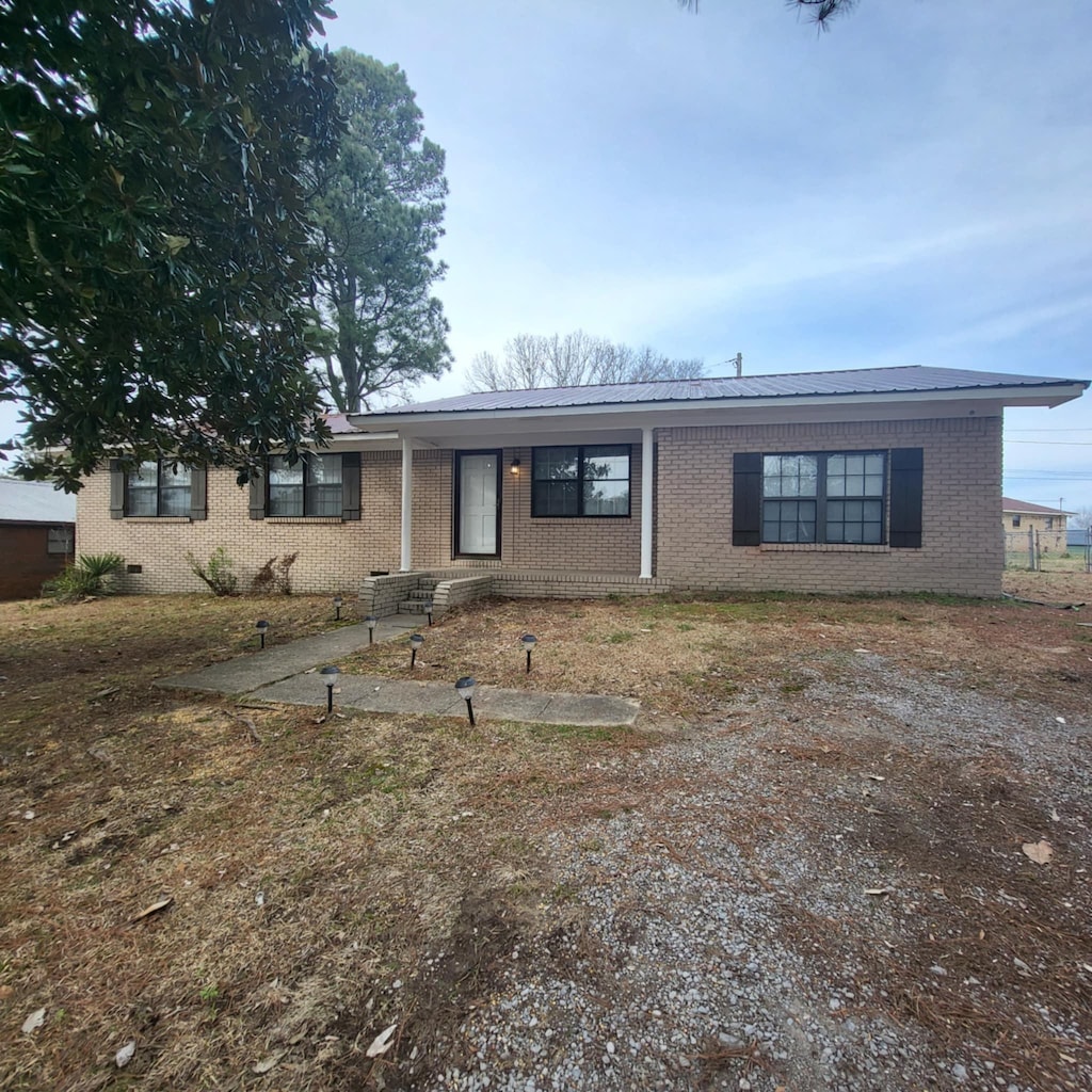  - ranch-style house with metal roof and brick siding