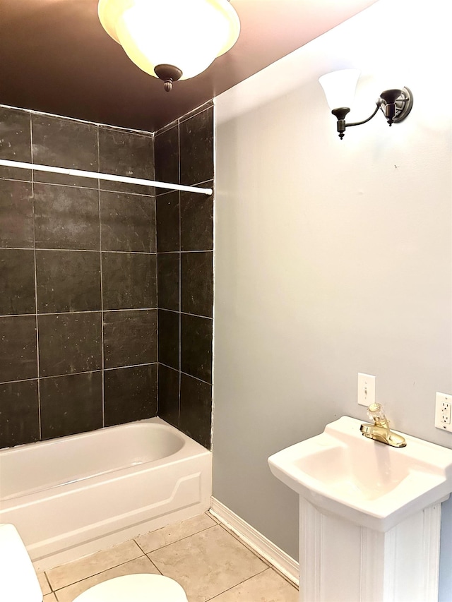 bathroom featuring tile patterned flooring, tiled shower / bath combo, and toilet