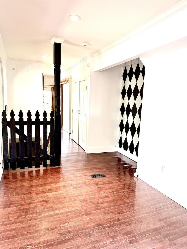 spare room featuring crown molding and hardwood / wood-style floors