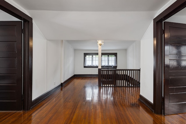  - bonus room featuring baseboards, a notable chandelier, and hardwood / wood-style flooring