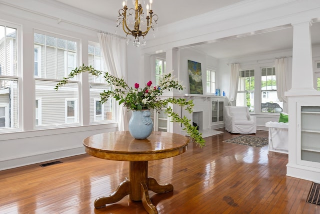  - interior details featuring visible vents, wood finished floors, a notable chandelier, and a fireplace