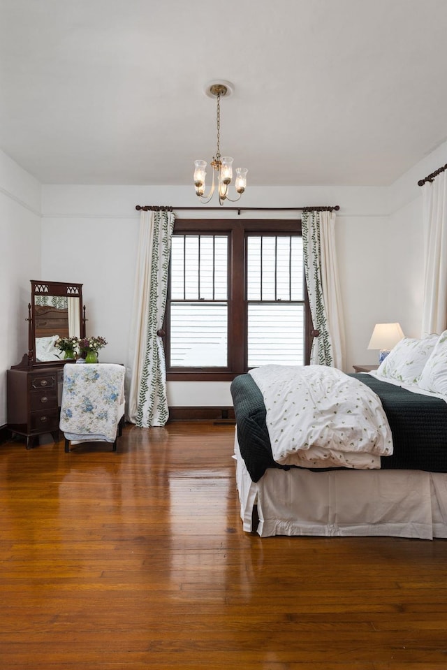  - bedroom with an inviting chandelier and wood finished floors