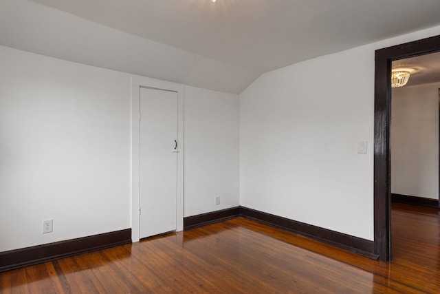  - empty room with baseboards, wood finished floors, and lofted ceiling