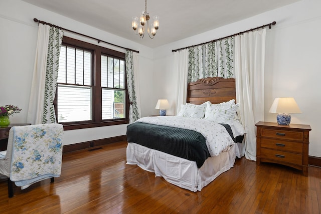  - bedroom with wood-type flooring, baseboards, a notable chandelier, and visible vents
