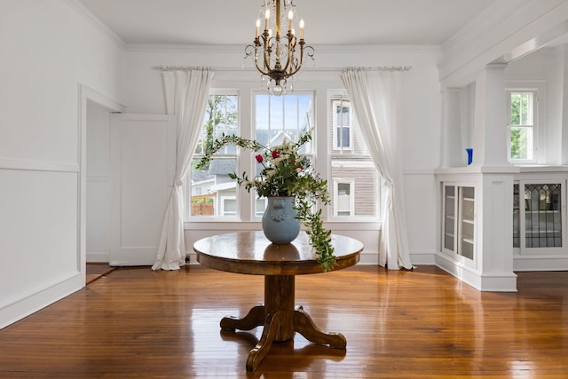  - dining area with an inviting chandelier, ornamental molding, and hardwood / wood-style flooring