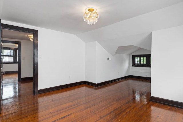 - additional living space featuring baseboards, vaulted ceiling, hardwood / wood-style flooring, and a chandelier
