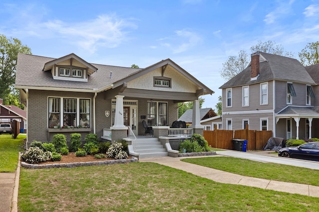  - view of front of house with brick siding, a front lawn, and covered porch