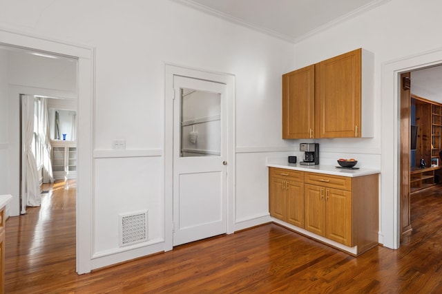  - kitchen with brown cabinets, ornamental molding, dark wood-style floors, and visible vents