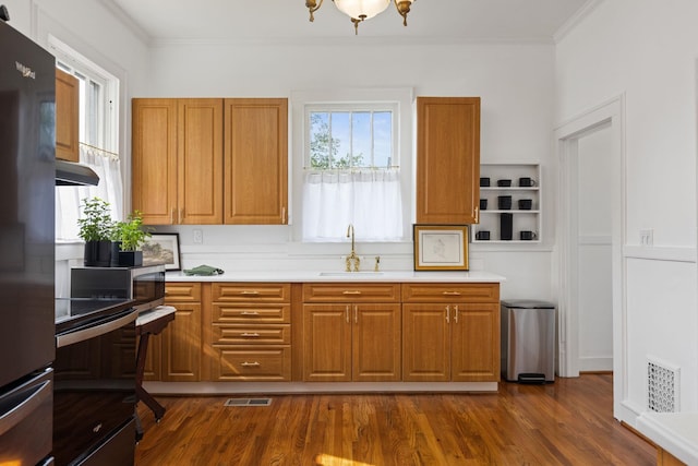  - kitchen with crown molding, visible vents, a sink, and light countertops