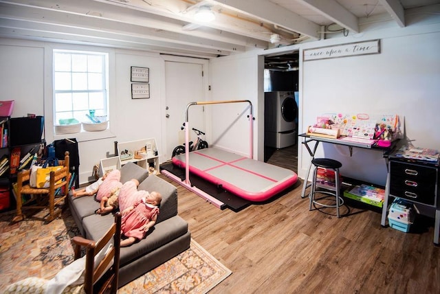 bedroom with beam ceiling, washer / dryer, and wood-type flooring