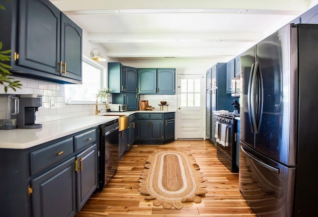 kitchen featuring beam ceiling, decorative backsplash, a healthy amount of sunlight, and black appliances