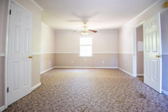 carpeted spare room featuring ceiling fan and crown molding