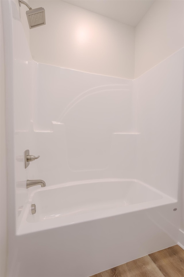 bathroom featuring bathtub / shower combination and wood finished floors