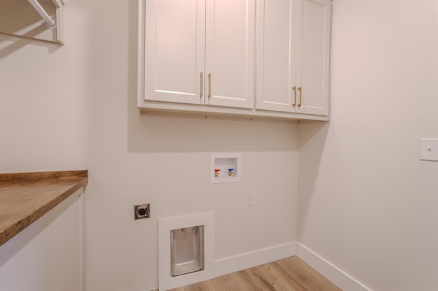 laundry area with hookup for a washing machine, cabinet space, light wood-style flooring, hookup for an electric dryer, and baseboards