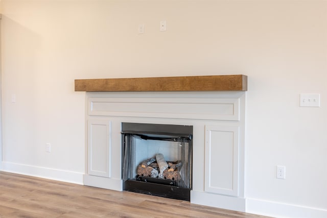 details with a fireplace, wood finished floors, and baseboards