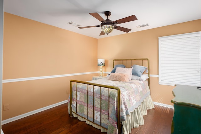 bedroom featuring wood finished floors, visible vents, and baseboards