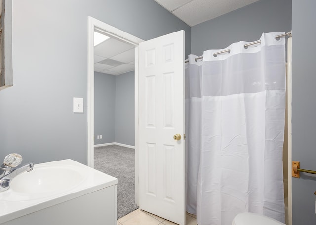 bathroom featuring a paneled ceiling, a shower with curtain, tile patterned flooring, and vanity