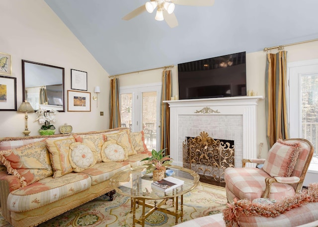 living room featuring a ceiling fan, a fireplace, and vaulted ceiling