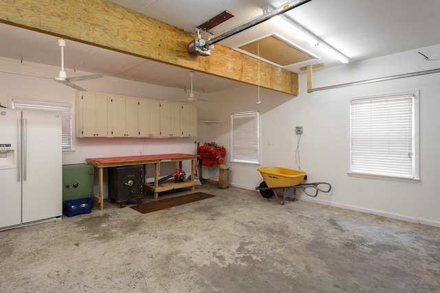 garage featuring baseboards, white fridge with ice dispenser, and a garage door opener