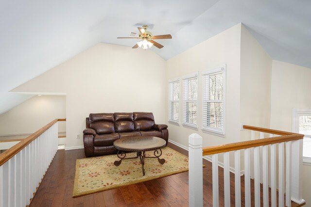 living room featuring baseboards, vaulted ceiling, and hardwood / wood-style floors