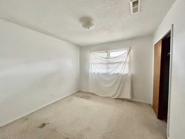 carpeted spare room with a textured ceiling